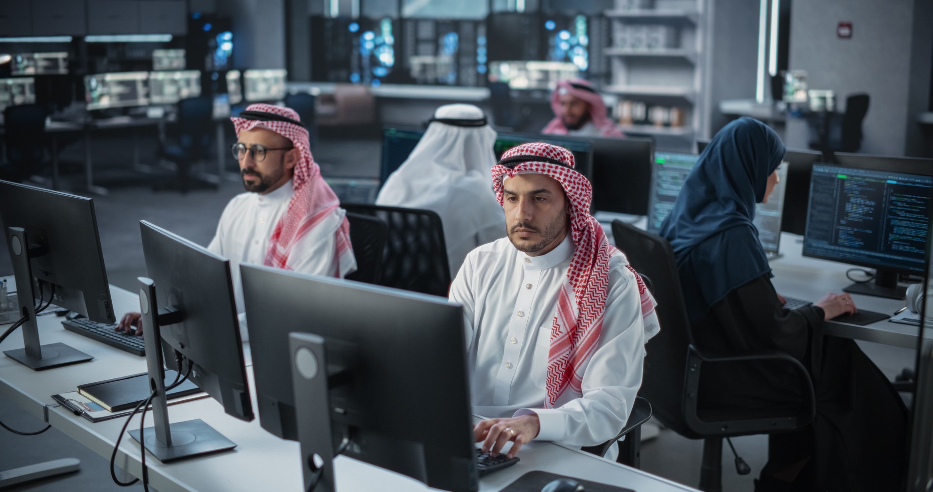 Team of Talented Young Middle Eastern Professionals Working in a Technological Research and Development Agency. Computer Screens with Software Code and Technical Neural Network Diagrams